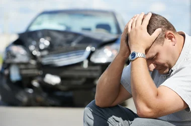 A man with his head in his hands following an auto accident
