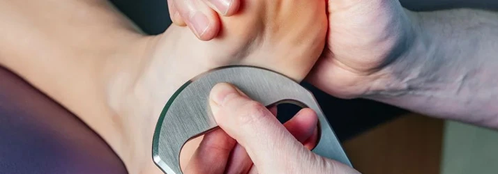 A provider using IASTM on a patient's foot