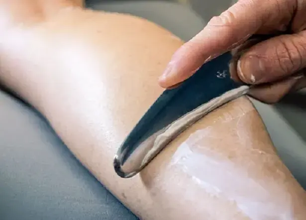 IASTM therapy against a patient's leg