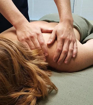 A massage therapist performing a shoulder massage